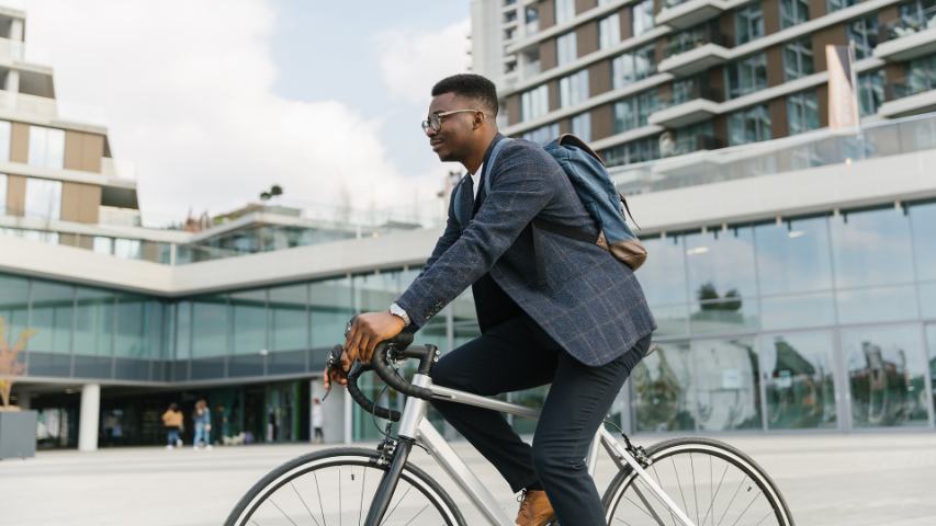 Young businessman riding a bicycle to work in the urban city zone 