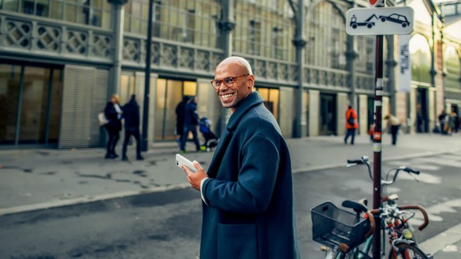 handsome young african american businessman walking down the street, going to work