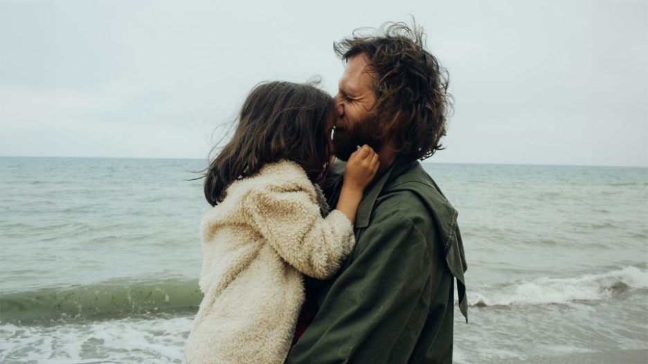 father and daughter are playing on the beach