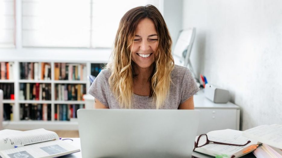 smiling woman with long hair working at home