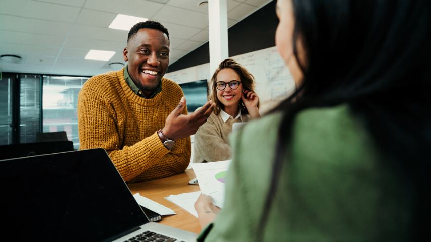 Male and two females in conversation during meeting