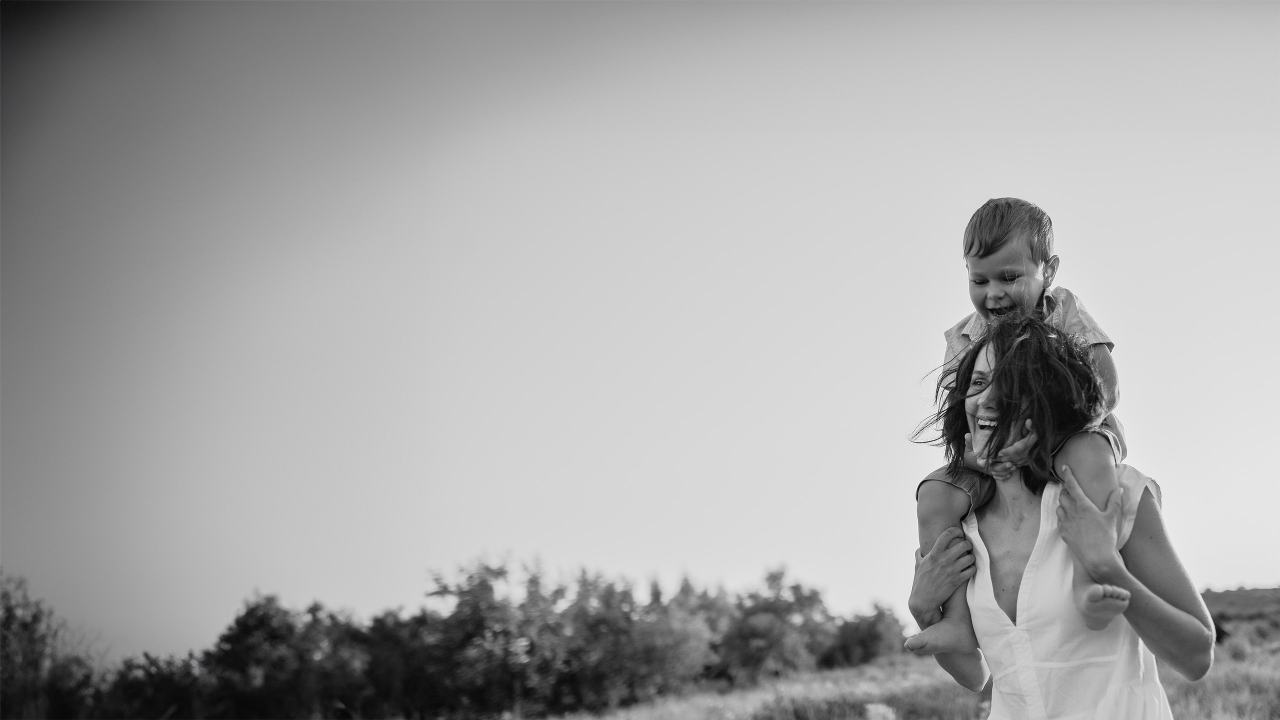 black and white young boy on mums shoulders