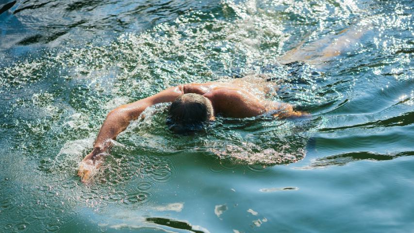 man swimming in lake