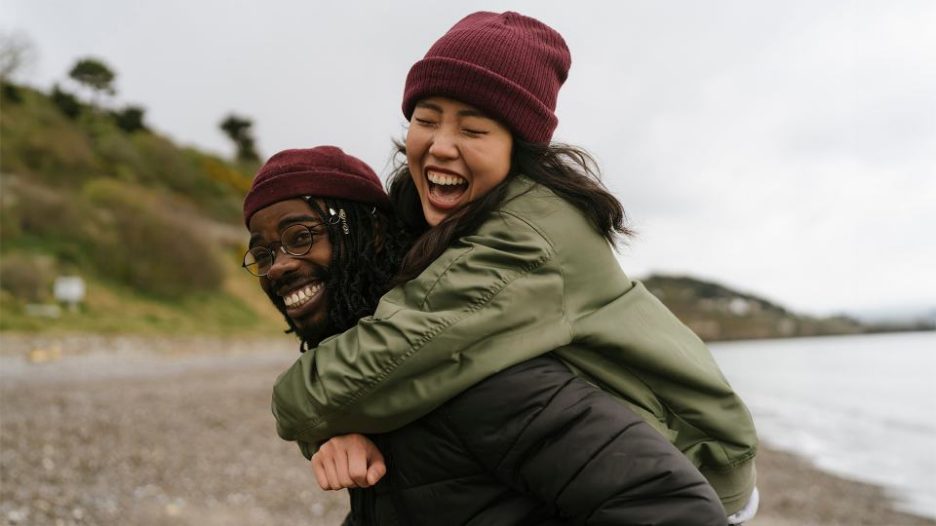 young couple having fun on the beach on a cloudy day