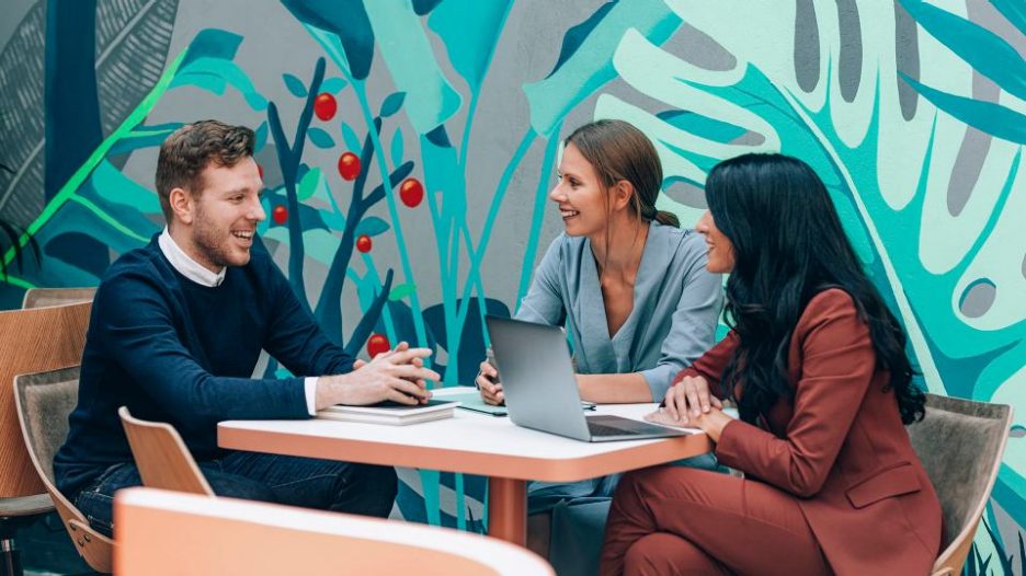 two  businesswomen and young  businessman talking during job interview at modern company.